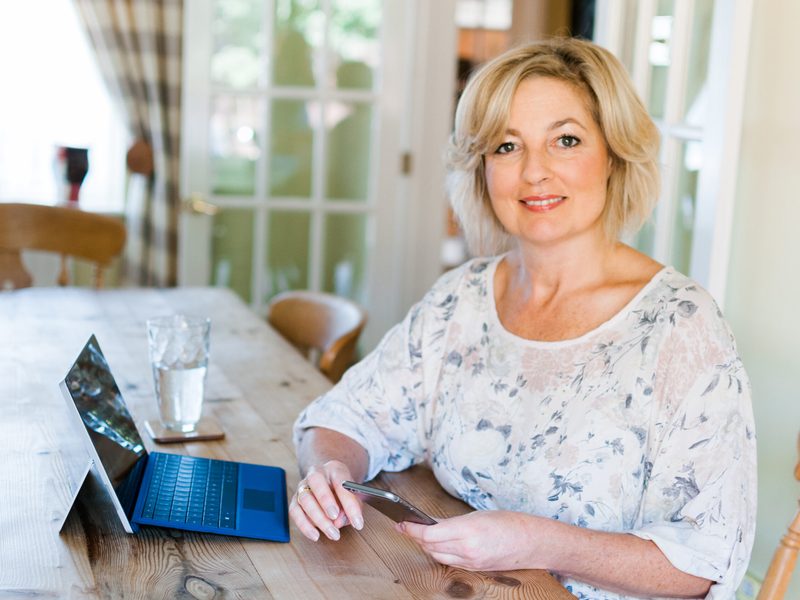 Lynne James at her kitchen table with a laptop